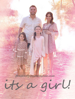 Family posing outside, dressed in pink; with the words "it's a girl!" written below.