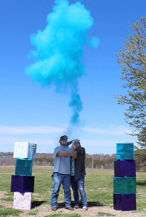 Couple posing under a cloud of blue powder.