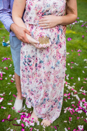 Couple posed with the focus on the mom's pregnant belly.