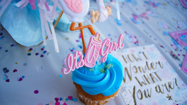 A cupcake with blue icing with a candle that says 