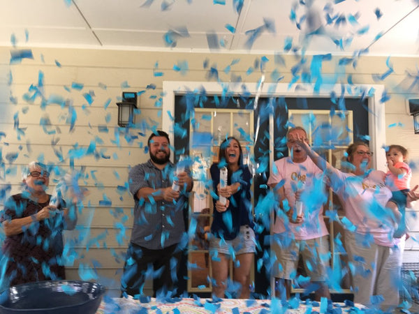 Couple celebrating with friends and family while shooting blue confetti.