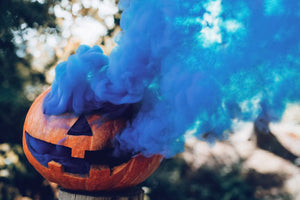 Pumpkin with blue smoke coming out of it.