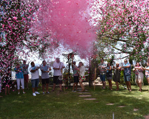 These friends and family added pink gender reveal powder and confetti cannons to their Hawaiian themed gender reveal