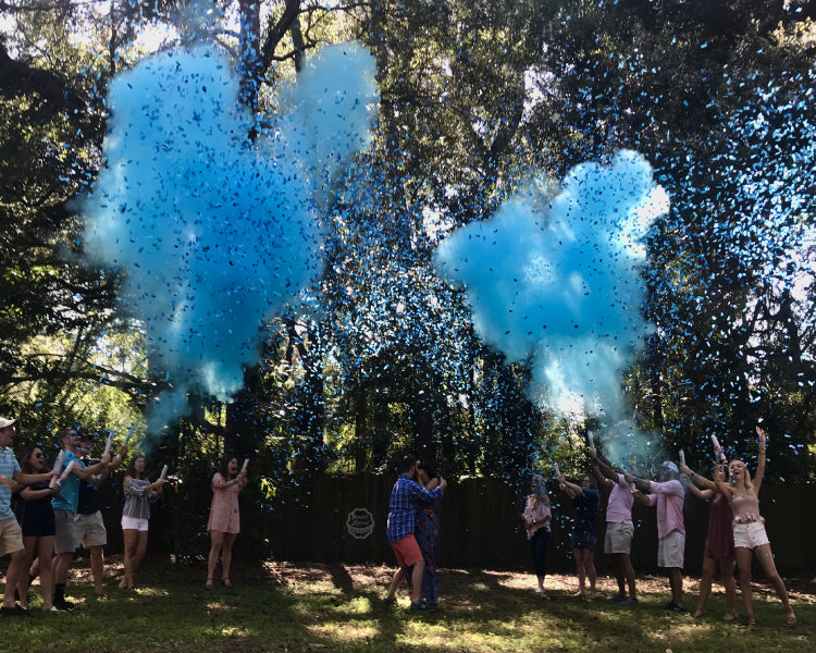 Guests celebrating with our blue confetti and powder mixture cannons as they reveal the parents to be are having a boy